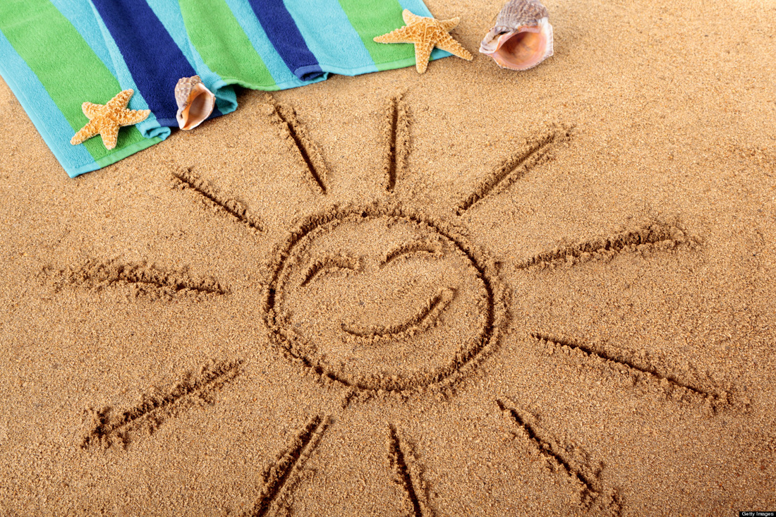 A sun with a happy face drawn in the sand